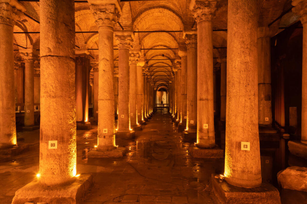 Dimly lit Basilica Cistern in Istanbul featuring rows of ancient marble columns reflected in shallow water.