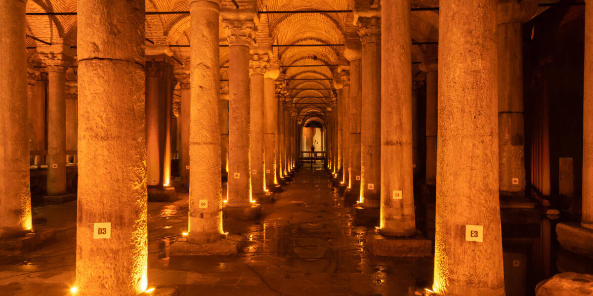 Dimly lit Basilica Cistern in Istanbul featuring rows of ancient marble columns reflected in shallow water.