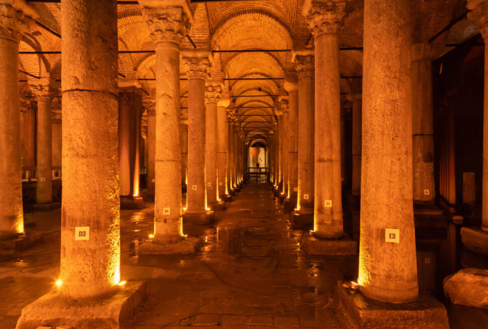 Dimly lit Basilica Cistern in Istanbul featuring rows of ancient marble columns reflected in shallow water.