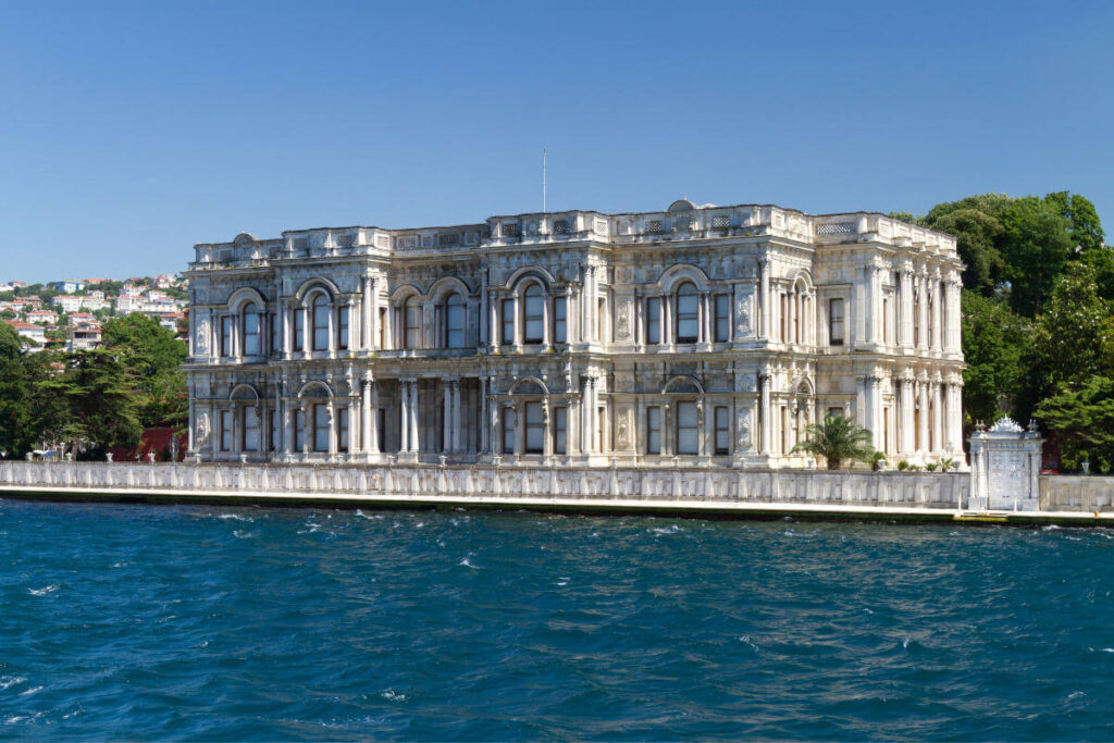 Ornate white Beylerbeyi Palace with arched windows on the Bosphorus shoreline in Istanbul, Turkey.