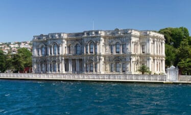 Ornate white Beylerbeyi Palace with arched windows on the Bosphorus shoreline in Istanbul, Turkey.