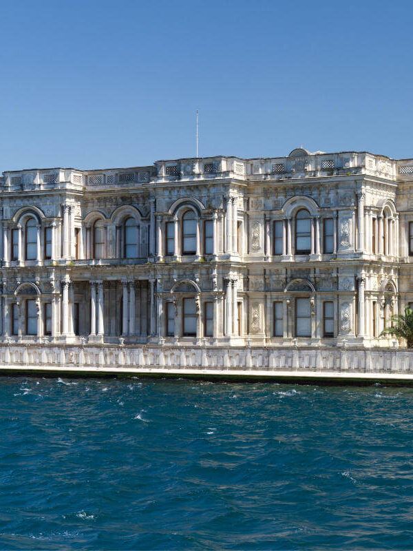 Ornate white Beylerbeyi Palace with arched windows on the Bosphorus shoreline in Istanbul, Turkey.