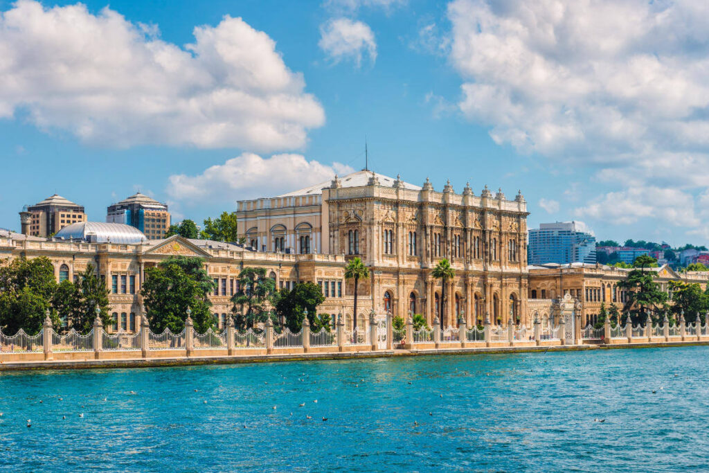 Elegant Dolmabahçe Palace facing the Bosphorus Strait, featuring ornate architecture and waterfront views in Istanbul.