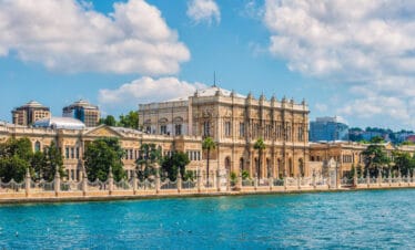 Elegant Dolmabahçe Palace facing the Bosphorus Strait, featuring ornate architecture and waterfront views in Istanbul.