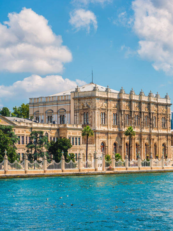 Elegant Dolmabahçe Palace facing the Bosphorus Strait, featuring ornate architecture and waterfront views in Istanbul.