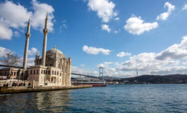 Elegant Ortaköy Mosque with twin minarets beside the Bosphorus and Bosphorus Bridge in Istanbul, Turkey