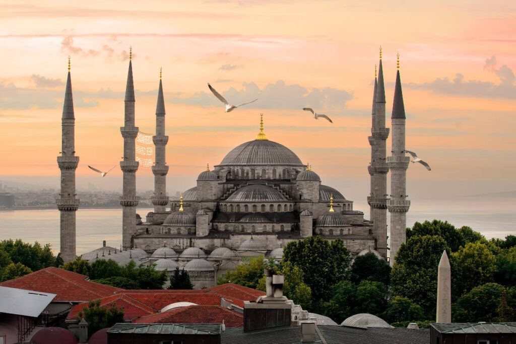 Majestic Blue Mosque with six minarets and seagulls flying above at sunset in Istanbul, Turkey.