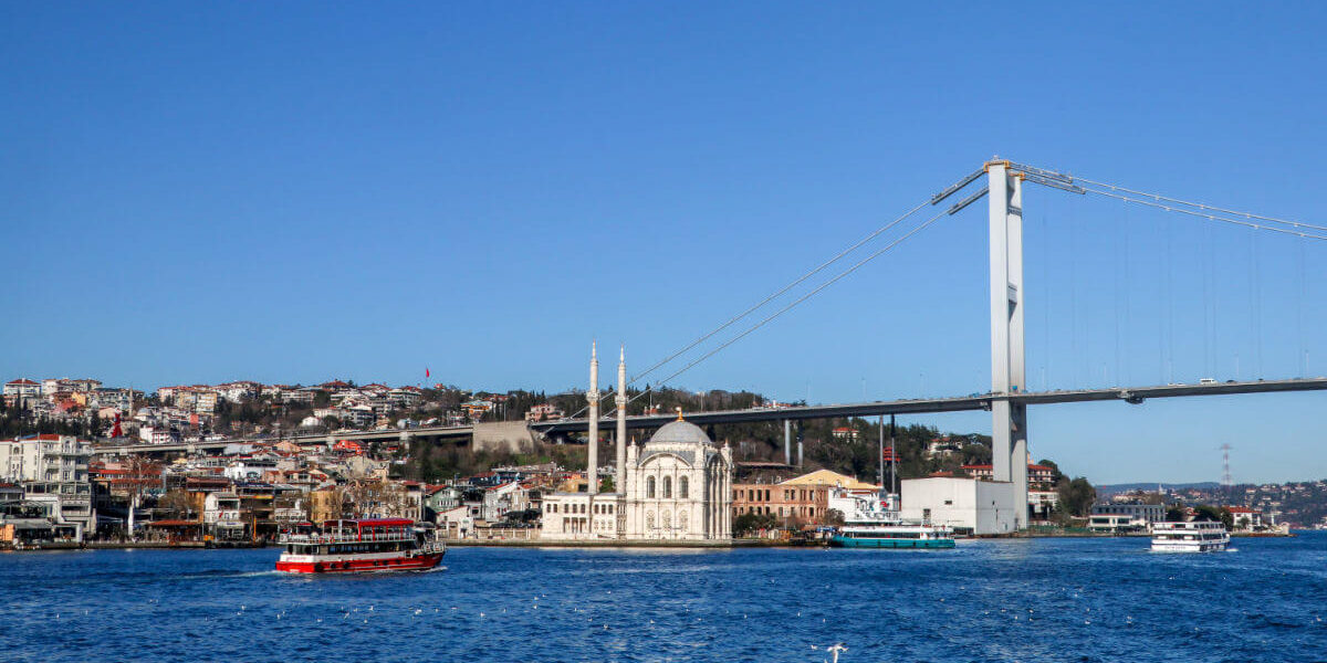 Ortaköy Mosque on the Bosphorus waterfront with the Bosphorus Bridge stretching across the background in Istanbul.
