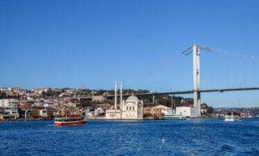 Ortaköy Mosque on the Bosphorus waterfront with the Bosphorus Bridge stretching across the background in Istanbul.