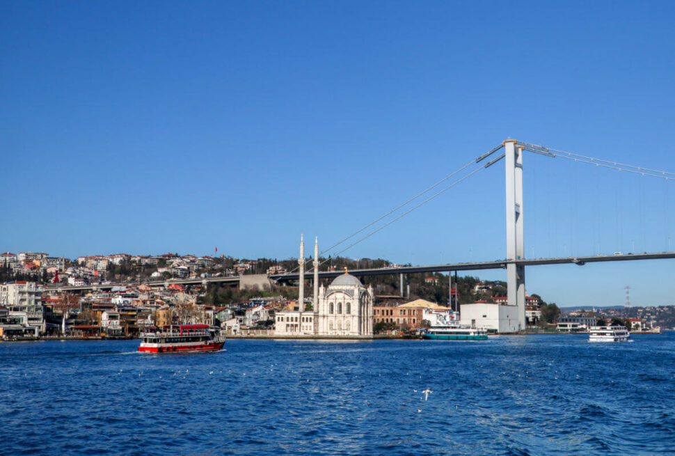 Ortaköy Mosque on the Bosphorus waterfront with the Bosphorus Bridge stretching across the background in Istanbul.