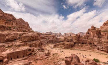 Panoramic view of Petra’s rock-cut city in Jordan, showcasing carved facades, sandstone cliffs, and ancient Nabatean tombs.