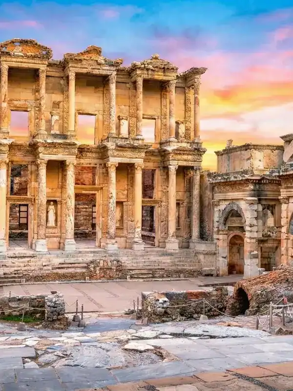 Magnificent facade of the Celsus Library in Ephesus Ancient City, Izmir, Turkey, under a bright and clear sunset sky.