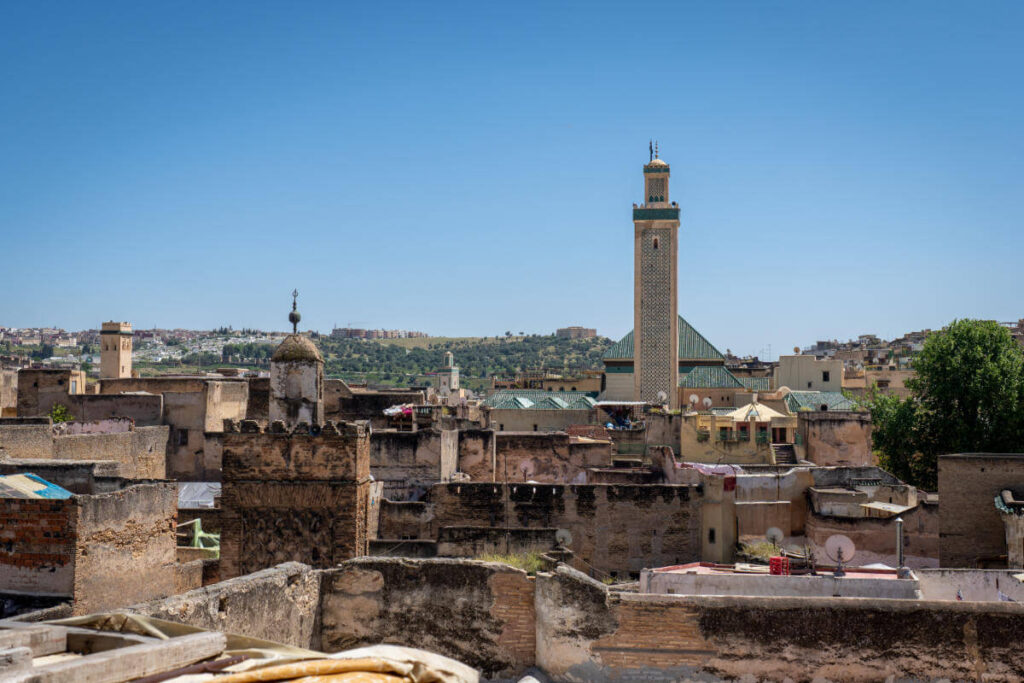 Panoramic view of Fes el Bali with Al-Qarawiyyin Mosque minaret in Fes, Morocco under clear blue sky.