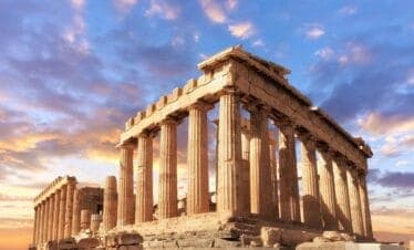 Majestic Parthenon temple in Athens with golden sunlight and vibrant sky highlighting its classical columns.