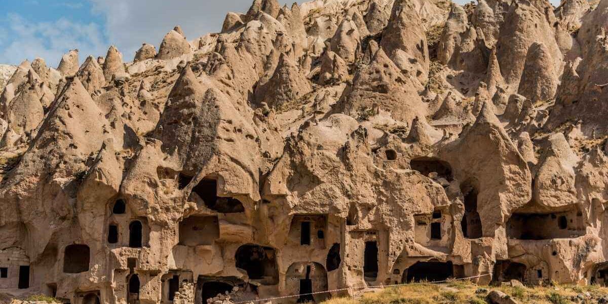 Ancient cave dwellings carved into cone-shaped rock formations at Zelve Open Air Museum in Cappadocia, Turkey.
