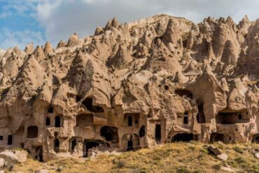 Ancient cave dwellings carved into cone-shaped rock formations at Zelve Open Air Museum in Cappadocia, Turkey.