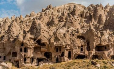 Ancient cave dwellings carved into cone-shaped rock formations at Zelve Open Air Museum in Cappadocia, Turkey.