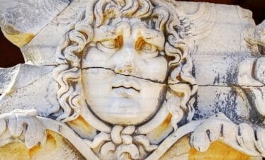 Medusa head relief at Didyma Ancient City, Aydın, with wavy hair and intricate Greco-Roman stone craftsmanship.