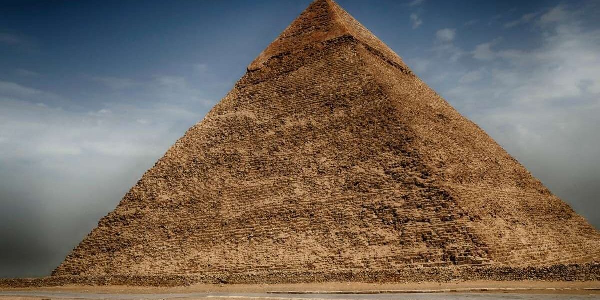 Great Pyramid of Cheops in Giza, Egypt, towering stone monument under a dramatic sky.