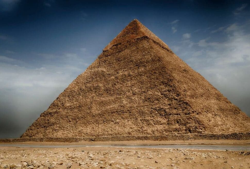 Great Pyramid of Cheops in Giza, Egypt, towering stone monument under a dramatic sky.