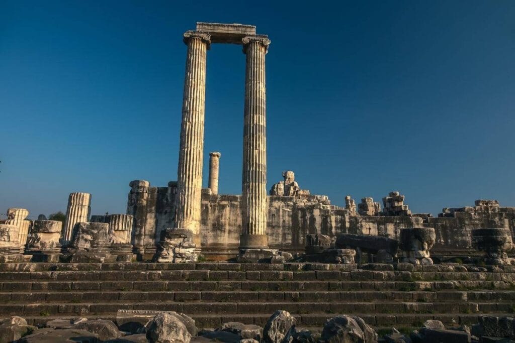 Ancient Temple of Apollo ruins in Didyma, Aydın, Turkey, with tall stone columns and steps under a clear blue sky.