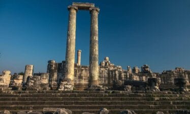 Ancient Temple of Apollo ruins in Didyma, Aydın, Turkey, with tall stone columns and steps under a clear blue sky.