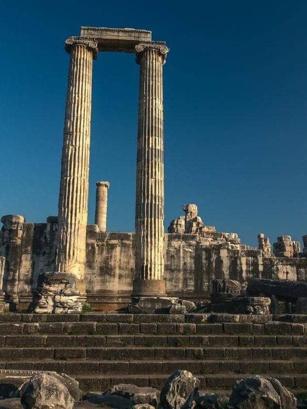 Ancient Temple of Apollo ruins in Didyma, Aydın, Turkey, with tall stone columns and steps under a clear blue sky.