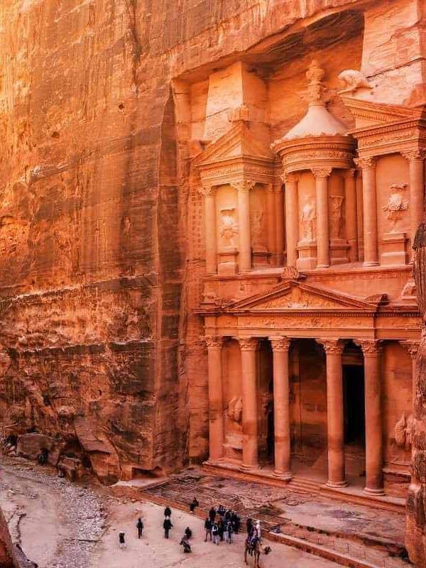 El Tesoro de Petra, en Jordania, enmarcado por acantilados de arenisca, cuenta con intrincadas tallas nabateas y visitantes en la entrada.