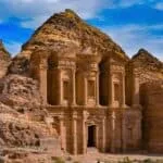 The Monastery in Petra, Jordan, carved into sandstone cliffs with towering columns and detailed Nabatean architecture.