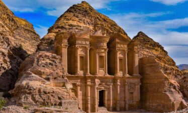 The Monastery in Petra, Jordan, carved into sandstone cliffs with towering columns and detailed Nabatean architecture.