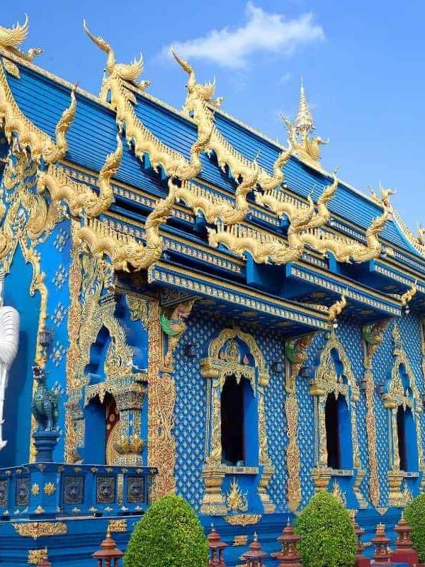 Wat Rong Suea Ten Blue Temple in Chiang Rai with golden carvings, vivid blue walls, and ornate Buddhist architecture.