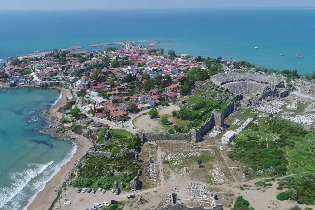Aerial view of Side Ancient City in Antalya showing the Roman theater, ruins, and coastal old town by the Mediterranean Sea.