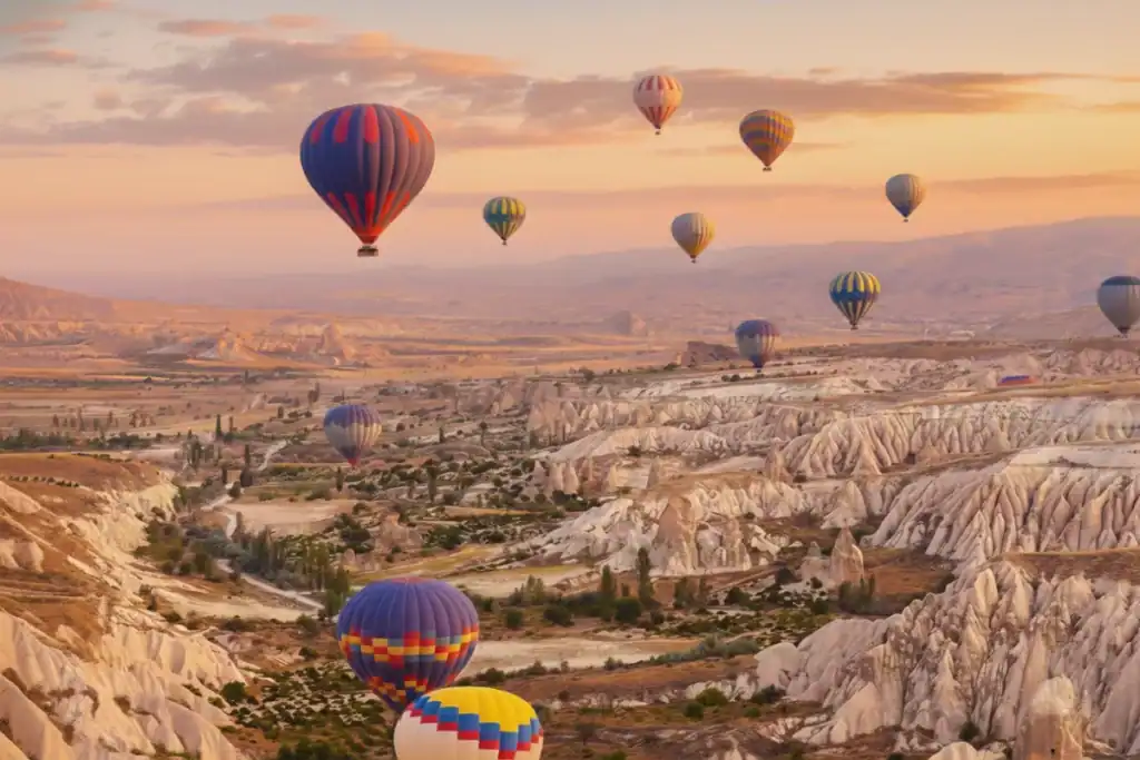 Globos aerostáticos coloridos sobrevolando los valles de Capadocia al amanecer durante una Excursión a Capadocia de 2 Días desde Estambul.