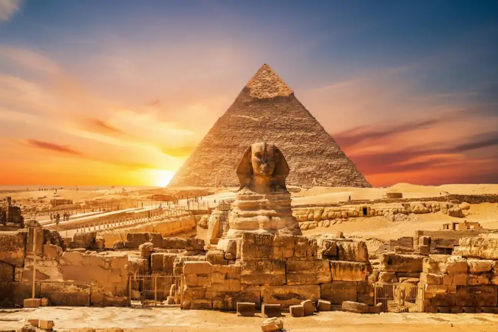 A cinematic and vibrant view of the Great Pyramid of Giza and the Sphinx in Egypt, featuring a surreal cosmic sunset with a starry galaxy sky and purple nebulae.