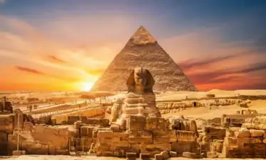 A cinematic and vibrant view of the Great Pyramid of Giza and the Sphinx in Egypt, featuring a surreal cosmic sunset with a starry galaxy sky and purple nebulae.