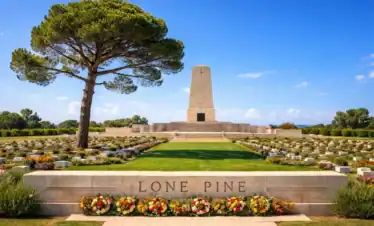 Lone Pine Australian Memorial in Gallipoli, Turkey with ANZAC battlefield cemetery, obelisk monument and lone pine tree under blue sky.
