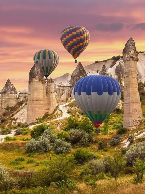 Paisaje espectacular de Capadocia con globos aerostáticos de colores volando sobre las chimeneas de hadas durante el amanecer en Turquía.