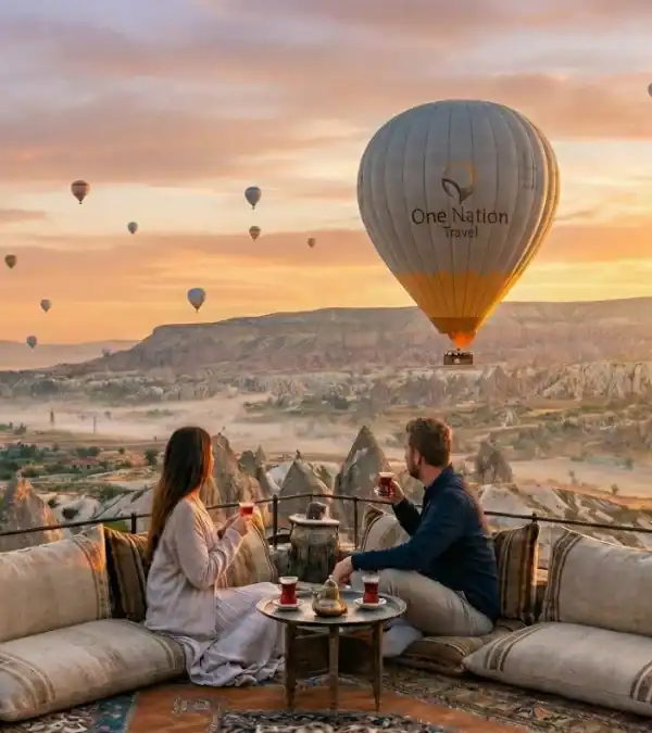 Couple watching sunrise hot air balloons in Cappadocia during one of our exclusive Turkey Tours from USA packages.