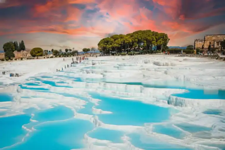 Pamukkale: Turkey's Thermal Wonderland 3 Vista panorámica de las piscinas de travertino blanco de Pamukkale bajo un cielo dramático al atardecer, un destino destacado en el tour de 4 días por Turquía.