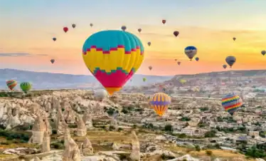 Hot Air Balloons flying over valleys during One Nation Travel Cappadocia Tours