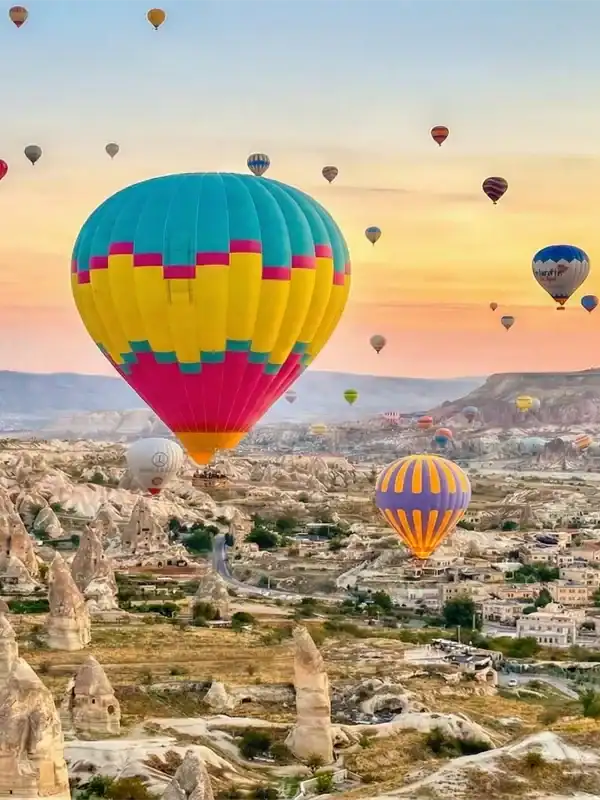Hot Air Balloons flying over valleys during One Nation Travel Cappadocia Tours