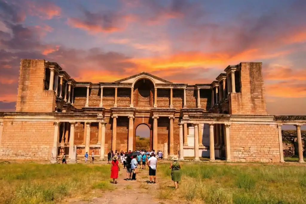 A vibrant sunset view of the monumental Roman Gymnasium at the Sardis Ancient City, a key stop on the Seven Churches of Revelation Tour in Turkey.