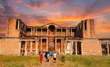 A vibrant sunset view of the monumental Roman Gymnasium at the Sardis Ancient City, a key stop on the Seven Churches of Revelation Tour in Turkey.