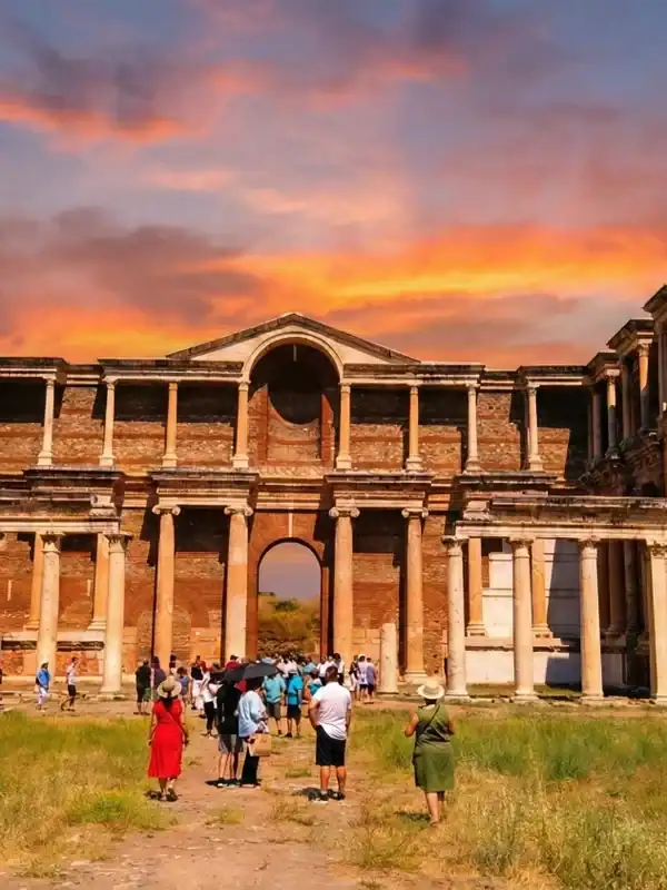 A vibrant sunset view of the monumental Roman Gymnasium at the Sardis Ancient City, a key stop on the Seven Churches of Revelation Tour in Turkey.