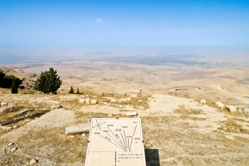Scenic view from Mount Nebo, Jordan overlooking vast desert landscapes, winding roads, and historic landmark markers