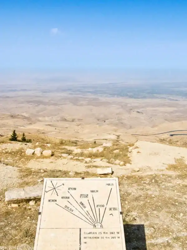 Scenic view from Mount Nebo, Jordan overlooking vast desert landscapes, winding roads, and historic landmark markers