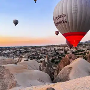 Cappadocia hot air balloons floating above fairy chimneys at sunrise, showcasing breathtaking volcanic rock landscapes.