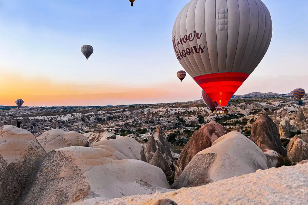 Cappadocia hot air balloons floating above fairy chimneys at sunrise, showcasing breathtaking volcanic rock landscapes.