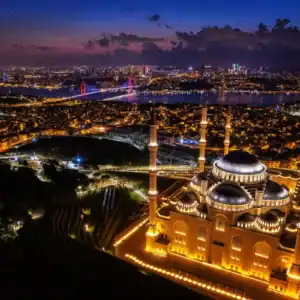 Illuminated Çamlıca Mosque and Bosphorus Bridge overlooking Istanbul’s glowing skyline at twilight from above