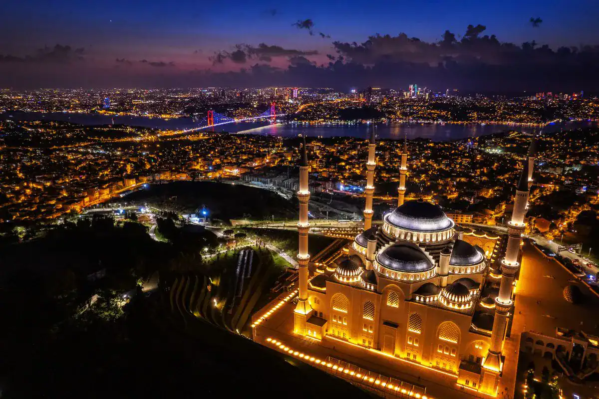 Illuminated Çamlıca Mosque and Bosphorus Bridge overlooking Istanbul’s glowing skyline at twilight from above